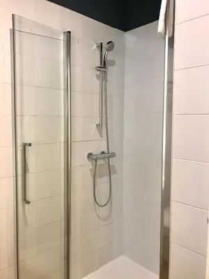 a shower in a bathroom with a glass door at Albergue O Burgo in O Pedrouzo