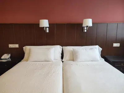 two beds in a hotel room with white pillows at Hotel EO in Ribadeo