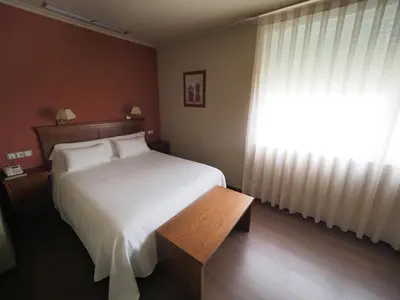 a bedroom with a white bed and a window at Hotel EO in Ribadeo