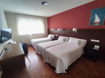 a hotel room with two beds and a flat screen tv at Hotel EO in Ribadeo