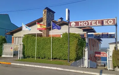 a hotel sign with flags in front of a building at Hotel EO in Ribadeo