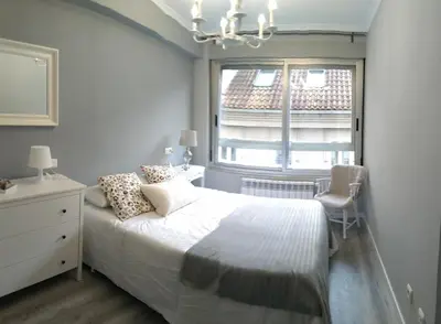 a bedroom with a white bed and a window at Torre Center in Santiago de Compostela