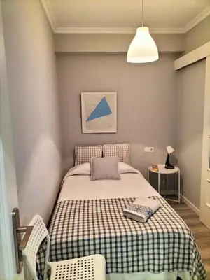 a bedroom with a bed with a checkered blanket at Torre Center in Santiago de Compostela