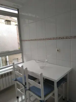 a white table and chairs in a room with a window at Torre Center in Santiago de Compostela