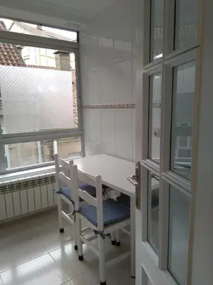 a white table and chair in a room with two windows at Torre Center in Santiago de Compostela