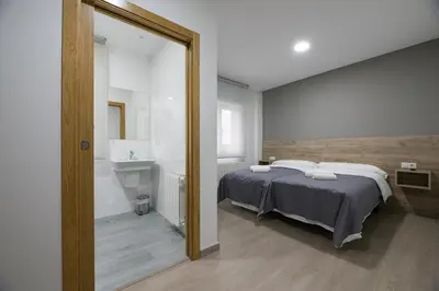 a bedroom with a bed and a sink and a mirror at A Chousa in Arzúa