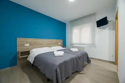 a blue bedroom with a bed with two towels on it at A Chousa in Arzúa