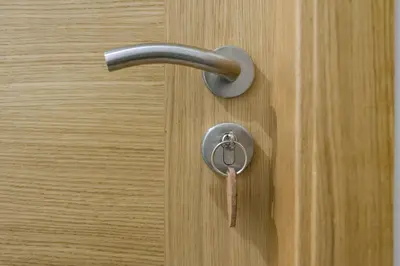 a door knob with a key on a wooden door at A Chousa in Arzúa