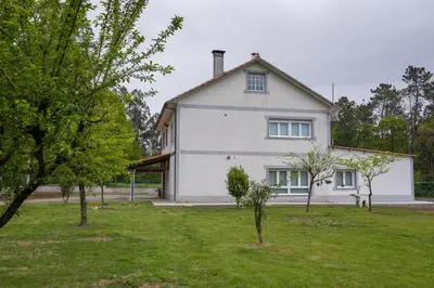 a white house with trees in front of it at A Chousa in Arzúa