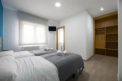 a bedroom with two beds with white sheets and a window at A Chousa in Arzúa