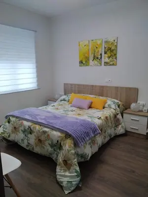 a bedroom with a large bed with colorful sheets at Apartamento Casco Antiguo Ponferrada in Ponferrada