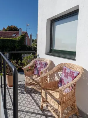 two wicker chairs and a window on a balcony at Casa Lourido in Sada