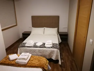 a bedroom with a bed with two towels on it at Pension Esquina in Melide