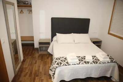 a bedroom with a bed with two towels on it at Pension Esquina in Melide