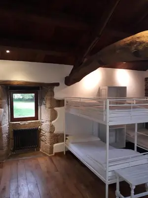 a room with bunk beds in a building with a window at Albergue o Xistral in Abadín