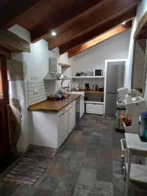 a kitchen with white cabinets and a refrigerator at Albergue o Xistral in Abadín