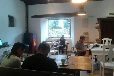 a group of people sitting at a table in a room at Albergue o Xistral in Abadín
