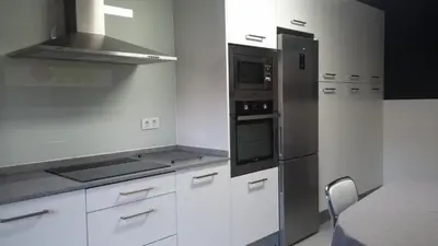 a kitchen with white cabinets and stainless steel appliances at Ourense Termal in Ourense