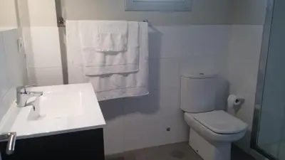 a bathroom with a toilet and a sink and towels at Ourense Termal in Ourense