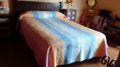 a bed with a blue and white blanket on it at O ollo do Mar in Viveiro