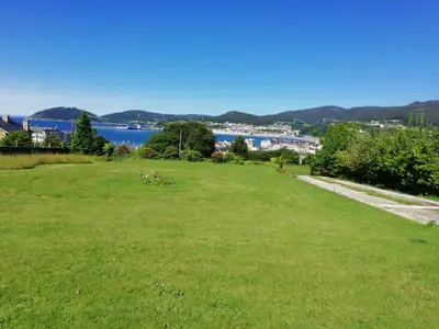 a field of green grass with a view of the water at O ollo do Mar in Viveiro
