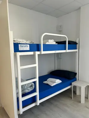 a bunk bed with a blue bottom bunk at Albergue SCQ in Santiago de Compostela
