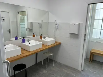 a bathroom with two sinks and a mirror at Albergue SCQ in Santiago de Compostela