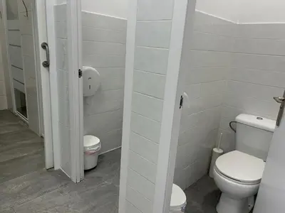 a white bathroom with a toilet and a sink at Albergue SCQ in Santiago de Compostela