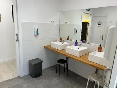 a bathroom with two sinks and a large mirror at Albergue SCQ in Santiago de Compostela