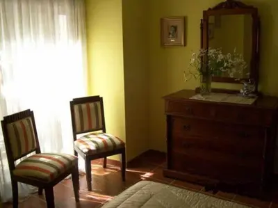 a bathroom with two chairs and a dresser and a mirror at Casa Alpargateiro in Os Peares
