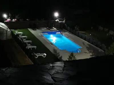a swimming pool at night with chairs around it at Cornatel Médulas in Borrenes