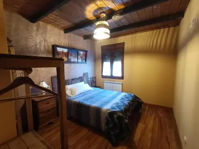 a bedroom with a bed with a blue comforter at Cornatel Médulas in Borrenes