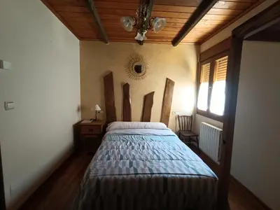 a bedroom with a bed and a wooden ceiling at Cornatel Médulas in Borrenes