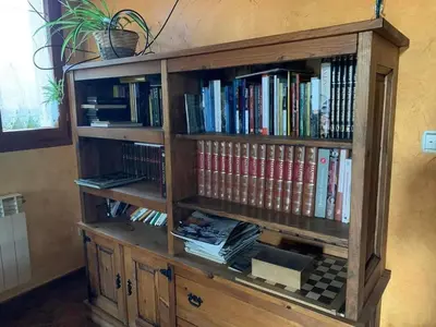a wooden book shelf filled with books at Cornatel Médulas in Borrenes