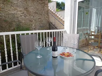 a glass table with a bottle of wine and wine glasses at La Casita de Plata in Monforte de Lemos