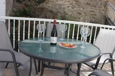 a glass table with a bottle of wine and wine glasses at La Casita de Plata in Monforte de Lemos