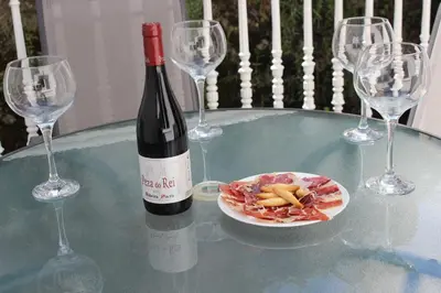 a bottle of wine and a plate of food on a table at La Casita de Plata in Monforte de Lemos