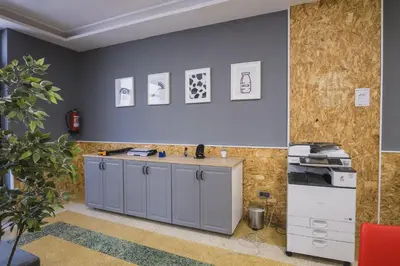 a kitchen with grey cabinets and pictures on the wall at Hotel Alda Centro Ponferrada in Ponferrada