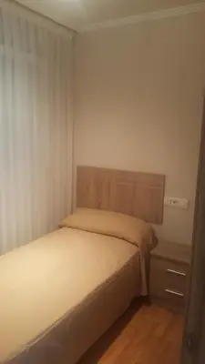 a bedroom with a bed with a wooden headboard at Costa do Castro in Foz