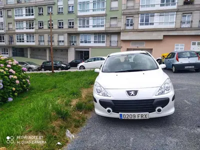 a white car parked in a parking lot in front of a building at Costa do Castro in Foz