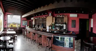 a bar in a restaurant with tables and chairs at Hotel Os Olivos in Guísamo