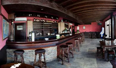 a bar in a restaurant with stools at Hotel Os Olivos in Guísamo