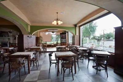 a restaurant with tables and chairs and a large window at Hotel Os Olivos in Guísamo