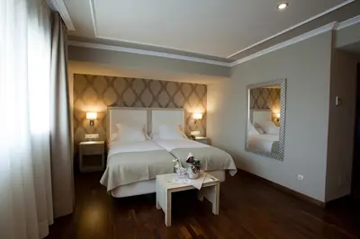 a bedroom with a bed and a table with a mirror at Hotel Os Olivos in Guísamo