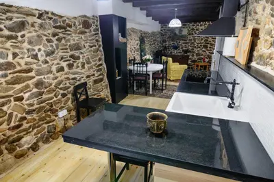 a kitchen with a sink and a stone wall at casa do peso in Monforte de Lemos