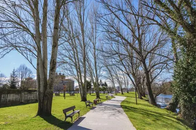 a walkway in a park with benches and trees at casa do peso in Monforte de Lemos
