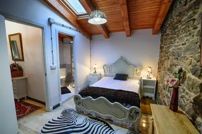 a bedroom with a bed and a stone wall at casa do peso in Monforte de Lemos