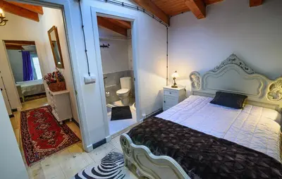 a bedroom with a large bed and a bathroom at casa do peso in Monforte de Lemos