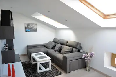 a living room with a couch and a skylight at Apartamento Vila O Valadouro in O Valadouro