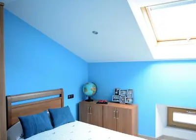 a bedroom with blue walls and a bed with blue pillows at Apartamento Vila O Valadouro in O Valadouro